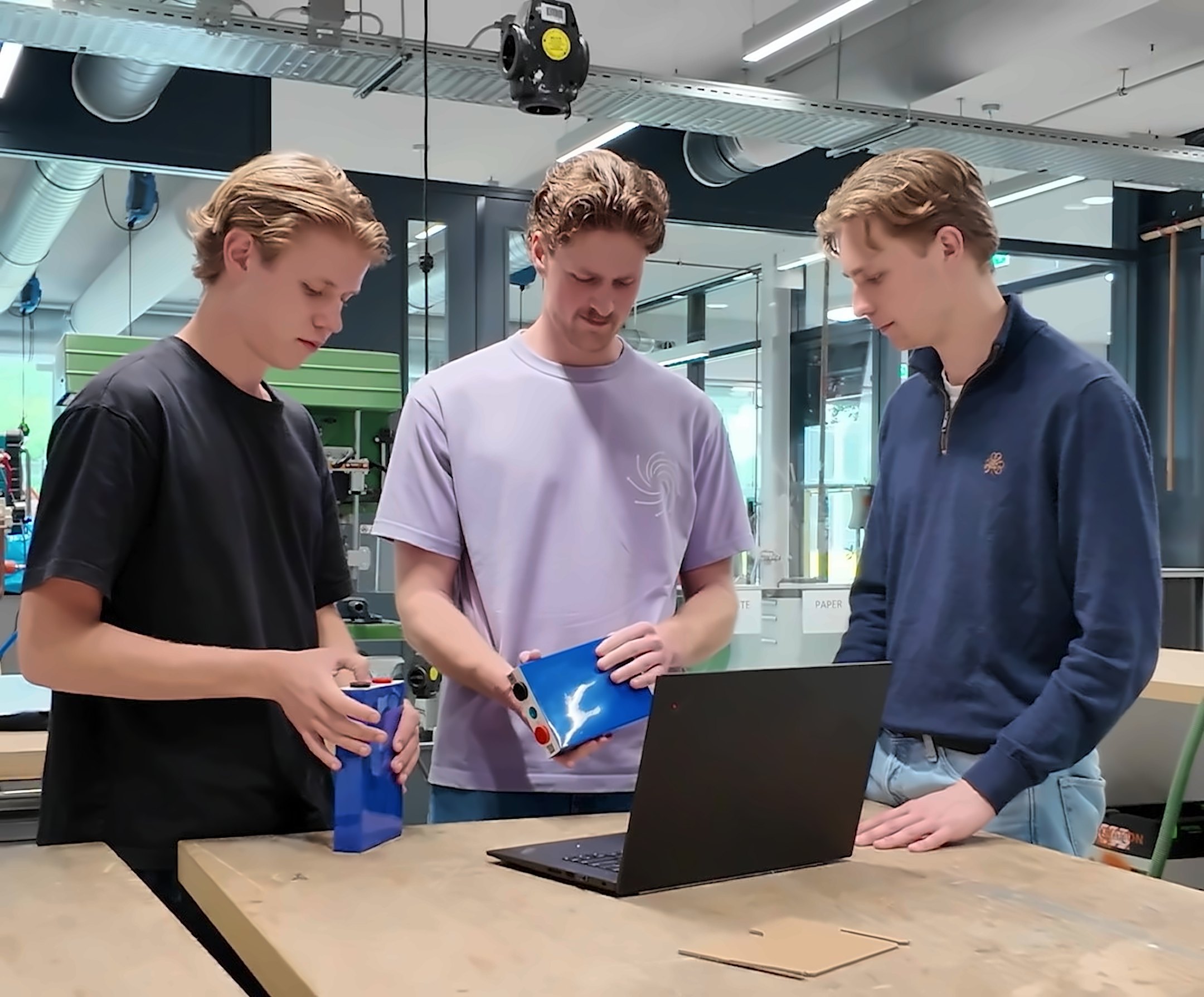 The Arc team in the workshop, looking at battery cells next to a laptop.